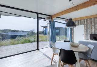 Heldere leefruimte in Sea Lodges «Bloemendaal 4» met grote ramen en duinzicht in Nederland.