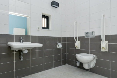 Aangepaste badkamer in Sea Lodges Bloemendaal 4 met steunen, wandwastafel en zwevend toilet.