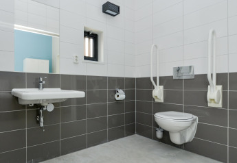 Barrierefreies Badezimmer in Sea Lodges Bloemendaal 4 mit Haltegriffen, Waschbecken und WC.