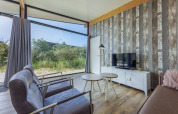 Salon moderne avec grandes fenêtres, vue nature et TV aux Sea Lodges Bloemendaal 3, Pays-Bas.