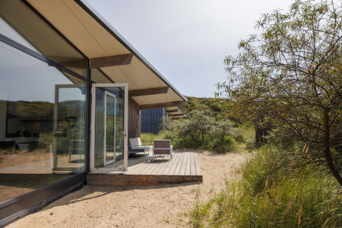 Buitenzicht op Sea Lodges Bloemendaal 3 in Nederland met een modern terras en groene natuur eromheen.