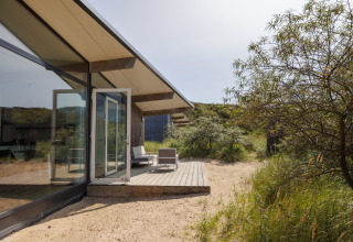 Buitenzicht op Sea Lodges Bloemendaal 3 in Nederland met een modern terras en groene natuur eromheen.