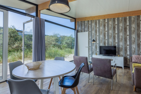 Lichte, moderne leefruimte in Sea Lodges Bloemendaal 3 in Nederland, met zicht op de natuur buiten.