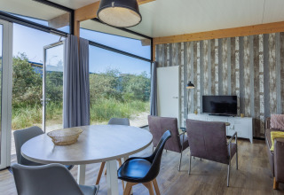 Lichte, moderne leefruimte in Sea Lodges Bloemendaal 3 in Nederland, met zicht op de natuur buiten.