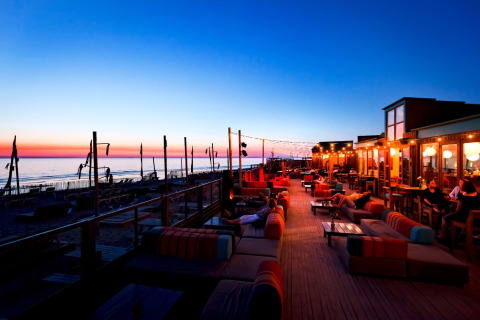 Vista nocturna en Sea Lodges «Bloemendaal 3» en los Países Bajos, con asientos exteriores y atardecer en la playa.