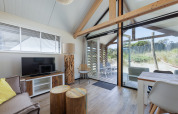 Helles Wohnzimmer im Sea Lodges Bloemendaal 2 mit modernen Möbeln und großem Panoramafenster.