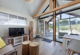 Heldere woonkamer in Sea Lodges Bloemendaal 2, Nederland, met grote ramen en moderne accenten.