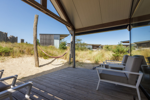 Uitzicht vanop het terras bij Sea Lodges Bloemendaal 2 in Nederland met hangmat en moderne zetels.