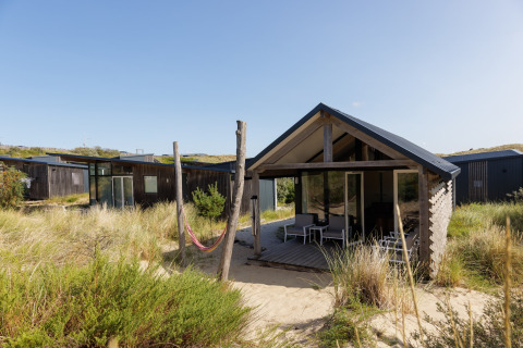 Strandhuis Sea Lodges Bloemendaal 2 in Nederland, gelegen tussen zandduinen en groene begroeiing.