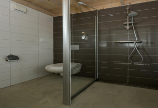 Moderne badkamer met zwevend toilet en douche bij Sea Lodges 'Bloemendaal 2', Nederland.