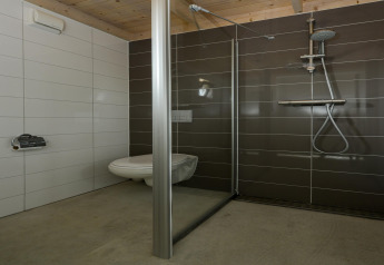 Modernes Badezimmer mit Wandtoilette und Regendusche in Sea Lodges „Bloemendaal 2“, Niederlande.