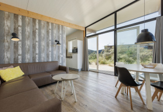Sala moderna en Sea Lodges Bloemendaal 1, Países Bajos, con ventanales y decoración elegante y luminosa.