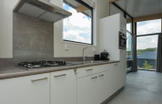 Cuisine moderne avec gazinière, évier et grandes fenêtres aux Sea Lodges Bloemendaal 1, Pays-Bas.