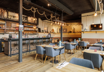 Modernes Restaurant und Bar bei Sea Lodges Bloemendaal 2 in den Niederlanden, stilvoll und einladend eingerichtet.