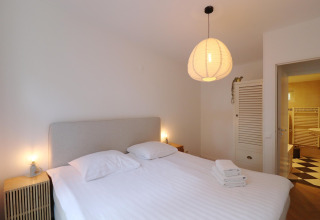 Moderne, hyggelig soveværelse på Wellnes suite lodge i Holland med dobbeltseng og udsigt til badeværelse.