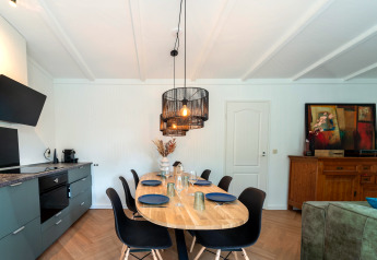 Dining and kitchen area in Forest Suite, Netherlands, modern decor, black chairs, and wall art accent.