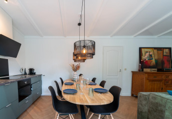 Dining and kitchen area in Forest Suite, Netherlands, modern decor, black chairs, and wall art accent.