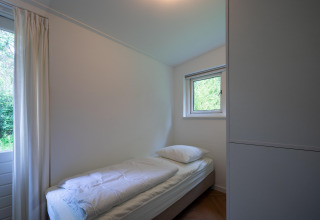 Bright single room at Forest suite lodge in the Netherlands, features single bed and nature view.