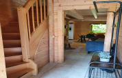 Ingang van een luxe 6-persoons bosvilla Casa Madeira in Nederland met houten interieur en trap.