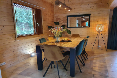 Comedor de la villa de lujo Casa Madeira en los Países Bajos, con paredes de madera y ambiente acogedor.
