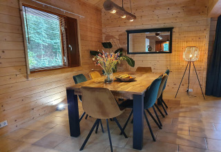 Dining area in the 6-person luxury forest villa Casa Madeira, Netherlands, with wood walls and cozy lighting.