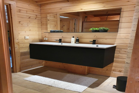 Moderne badkamer met zwart dubbel wastafelmeubel en houten wand in Casa Madeira, Nederland.