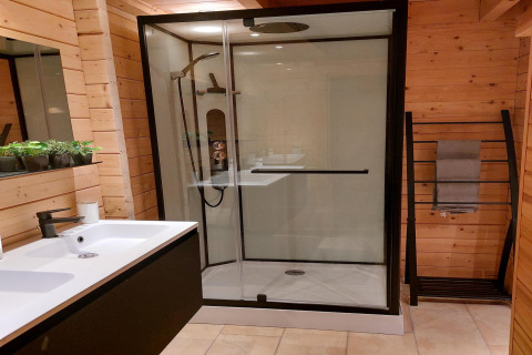 Salle de bain moderne en bois à Casa Madeira, Pays-Bas, avec douche vitrée, lavabo et porte-serviettes.