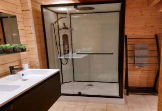 Salle de bain moderne en bois à Casa Madeira, Pays-Bas, avec douche vitrée, lavabo et porte-serviettes.