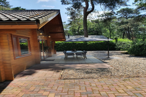 Udendørs terrasse ved skovvillaen Casa Madeira med overdækket spiseplads, omringet af natur.