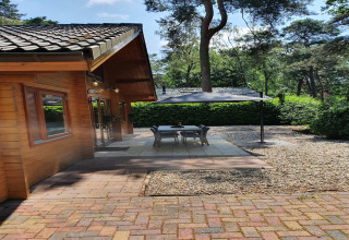 Terrasse der luxuriösen Waldvilla Casa Madeira in den Niederlanden mit Pavillon und Essbereich.