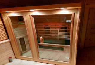 Luksuriøs infrarød sauna i træ med glasdør, oplyst fra oven, i Casa Madeira skovvilla, Holland.