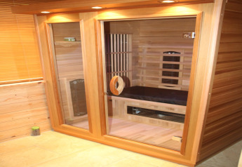 Modern indoor sauna with wood panels and glass doors at 6-person luxury villa Casa Madeira, Netherlands.