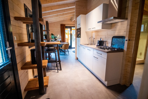 Modern interieur van een 4-persoons wellness lodge in Nederland met keuken, eethoek en houten muren.
