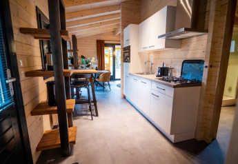 Intérieur moderne d'un lodge bien-être pour 4 personnes aux Pays-Bas avec cuisine et coin repas en bois.