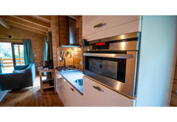 Moderne keuken en leefruimte in een 2-persoons wellness lodge in Nederland, veel hout en licht.