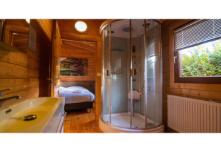 Badeværelse i en 2-personers wellness lodge i Holland, med bruseniche, vask og udsigt til soveværelse.