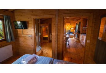Vue intérieure d’un lodge bien-être pour 2 personnes aux Pays-Bas avec sauna, chambre et salon.