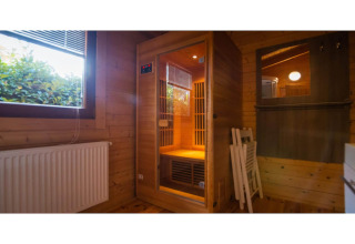 Et moderne wellness-lodgeværelse i Holland med en privat sauna, trævægge og store vinduer.
