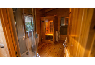 Indvendigt af en 2-personers wellness lodge i Holland med trævægge, sauna og store vinduer.