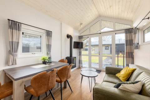 Salon et salle à manger lumineux dans une tiny house moderne au Holiday park Tolplas 19, Pays-Bas.