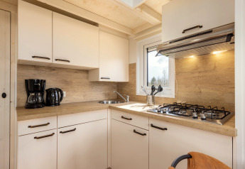Modernes kleines Ferienhaus-Küche mit Gasherd, Spüle, Kaffeemaschine und weißen Schränken im Tolplas 19.