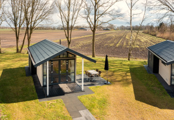 Winziges Ferienhaus im Holiday Park Tolplas 19, Niederlande, mit Terrasse und Blick auf Felder.