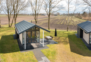 Tiny house nel Holiday Park Tolplas 19 nei Paesi Bassi, con terrazza che dà su prato e campi.