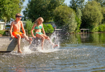 Zwei Kinder planschen am Steg am Wasser im Holiday Park Tolplas 19 in den Niederlanden.
