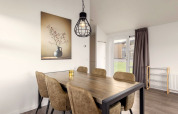 Essbereich in der Lodge im Holiday Park «Tolplas 18», Niederlande, mit Tisch, Stühlen und Wandbild.