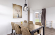 Essbereich in der Lodge im Holiday Park «Tolplas 18», Niederlande, mit Tisch, Stühlen und Wandbild.