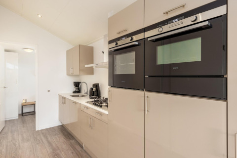 Cucina moderna con forni a incasso, piano cottura a gas e macchina da caffè al Tolplas 18 nei Paesi Bassi.