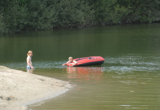 Deux enfants jouent près d’un lac avec un bateau gonflable au Holiday park Tolplas 19, aux Pays-Bas.