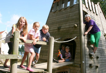Kinder und eine Erwachsene spielen am Ferienhaus im Holiday park Tolplas 19 in den Niederlanden.