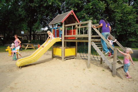 Children play on a playground with a slide at Holiday park Tolplas 19 in the Netherlands with their parents.